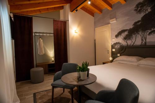a bedroom with a bed and a table and chairs at Relais La Dolce Vite in San Vendemiano