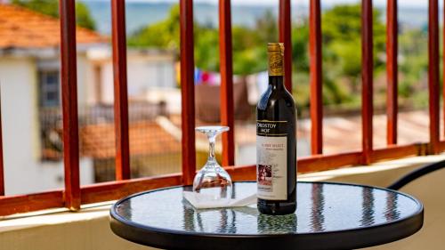 a bottle of wine sitting on a table with a wine glass at Whirlspring Hotel in Kisumu