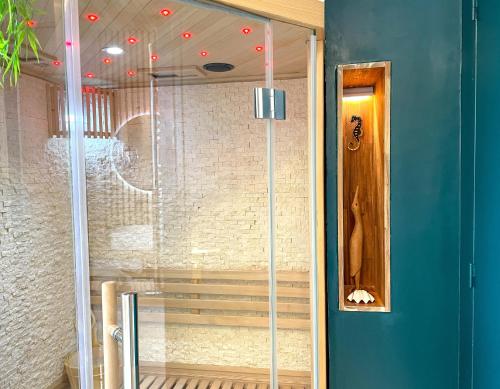 a shower in a room with a blue wall at Votre Escale Boule d Or Sauna & Spa in Niort