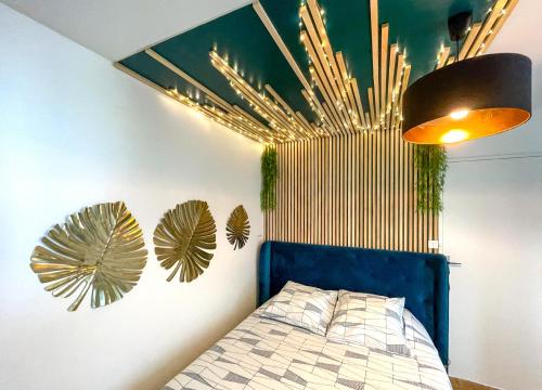 a bedroom with a bed with a blue head board at Votre Escale Boule d Or Sauna & Spa in Niort