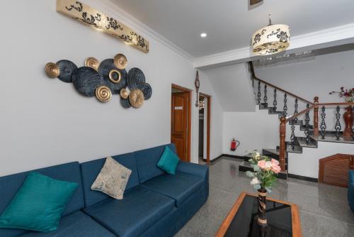 a living room with a blue couch and stairs at 5BHK Villa Calangute Phase 2, just 2 Min walk to Calangute Beach in Arpora