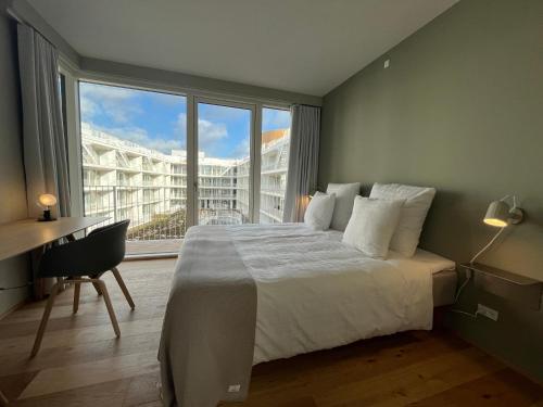 ein Schlafzimmer mit einem großen Bett, einem Schreibtisch und einem Fenster in der Unterkunft STAY Nordhavn in Kopenhagen