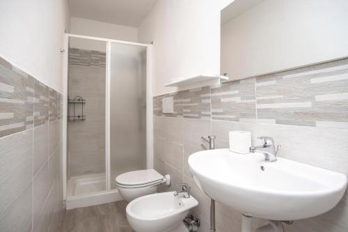 une salle de bain blanche avec un lavabo et des toilettes dans l'établissement Appartamenti Scaglieri, à Portoferraio