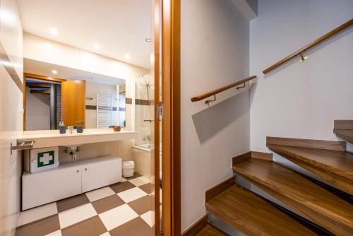 a bathroom with a sink and a toilet and a staircase at Cal Muntanyà in Puigcerdà