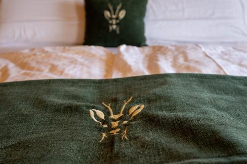 a spider on a green blanket on a bed at Teverone Suites & Wellness in Lamosano