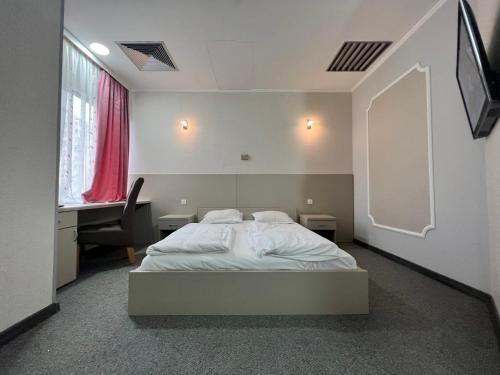 a bedroom with a bed and a desk and a window at Motel Carmen in Baia Mare