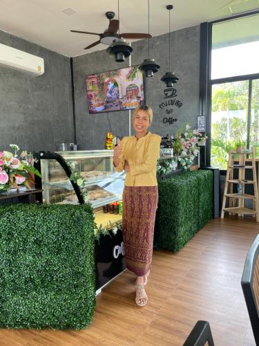 una mujer parada frente a una floristería en HR Resort 