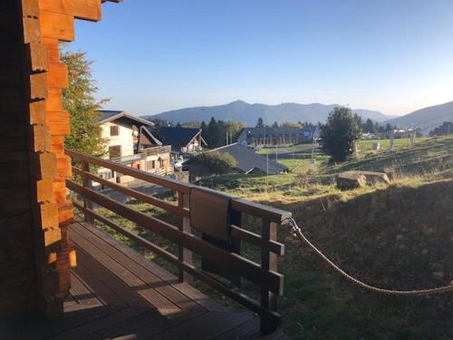 a wooden bench tied to a fence on a deck at CHALET 6 PERSONNES SUR PISTE in Boutx