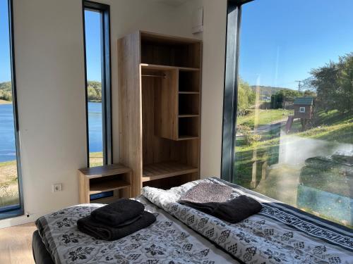 a bedroom with two beds and a large window at Haus TAO, am See in Zirkow