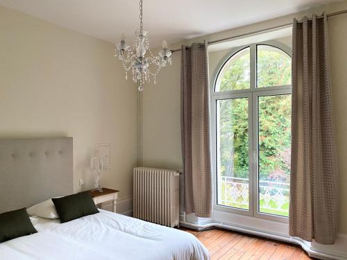 um quarto com uma cama e uma grande janela em Domaine de Bonneuil em Bonneuil-les-Eaux