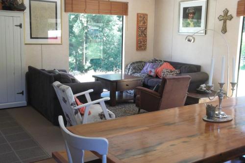 uma sala de estar com uma mesa e um sofá em Cosy Country Cottage - Outdoor Pizza Oven - Rural Setting on 4 Acres em Raetihi