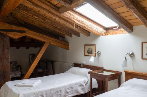 two beds in a room with wooden beams at Solar de Quintano in Labastida