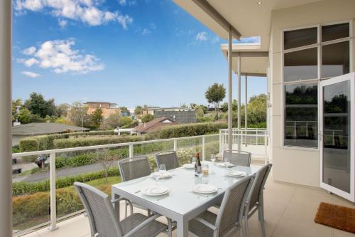 a dining room with a table and chairs on a balcony at Havelock Wine Down - Havelock North Holiday Home in Havelock North