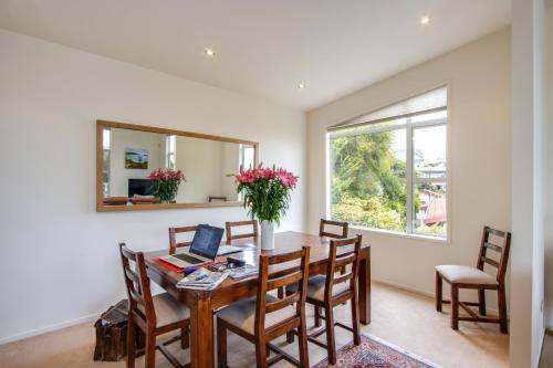 a dining room with a table with a laptop on it at Havelock Wine Down - Havelock North Holiday Home in Havelock North