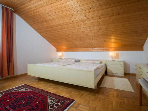 Schlafzimmer mit einem Bett mit Holzdecke in der Unterkunft Ferienwohnung Wilfried Schlor in Merzig