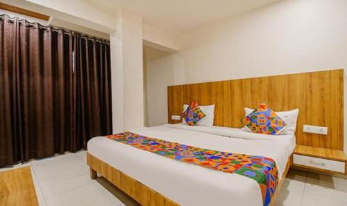 ein Schlafzimmer mit einem großen Bett und einem großen Fenster in der Unterkunft FabExpress Sunshine Regency in Bhopal
