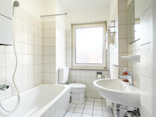 a bathroom with a tub and a toilet and a sink at Cosy & Central-Apartments in Gelsenkirchen in Gelsenkirchen