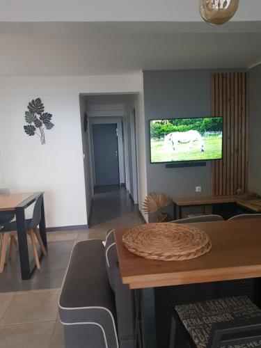 a living room with a table and a tv on the wall at bambôô in Les Avirons