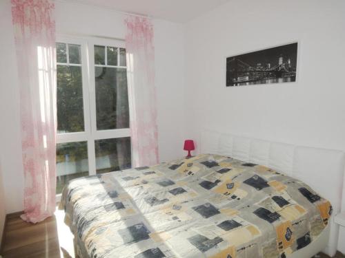 Schlafzimmer mit einem Bett und einem Fenster in der Unterkunft Bernstein 17 in Graal-Müritz