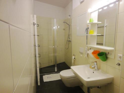 ein Bad mit einer Dusche, einem WC und einem Waschbecken in der Unterkunft Bernstein 17 in Graal-Müritz