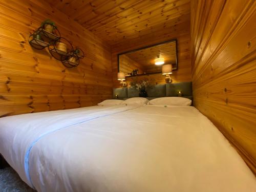 a large white bed in a wooden room at My Happy Garden 1500sq m in Ochsenfurt