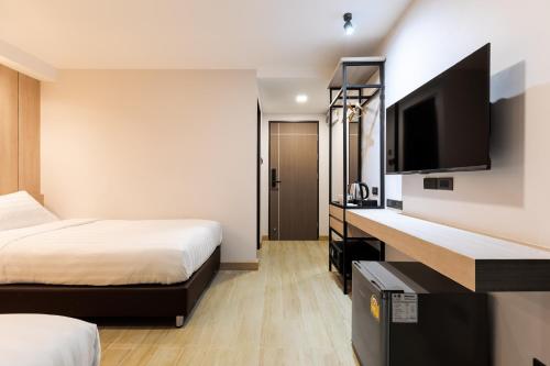 a hotel room with two beds and a flat screen tv at City Park Hotel Bangkok Pratunam by PCL in Bangkok