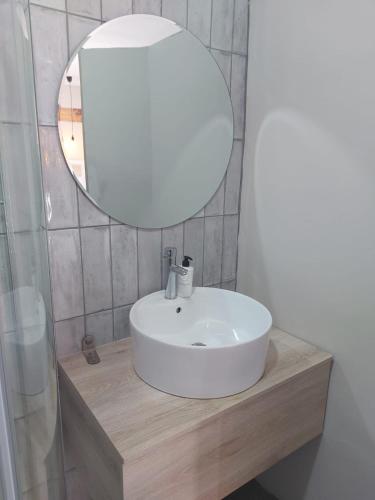 a bathroom with a white sink and a mirror at Lavender Lane Queenstown in Queenstown