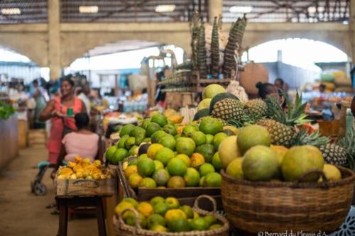 un mercado con cestas de frutas y hortalizas en villa Mena, en Nosy Be