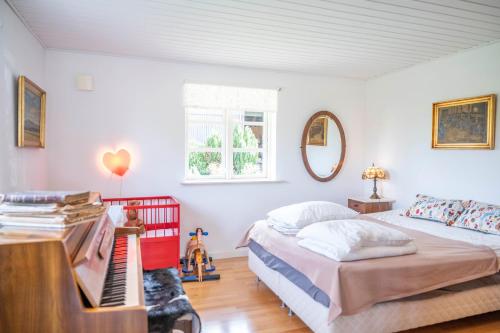 a bedroom with a bed and a piano at Skortskær Bondegårdsferie in Havnsø