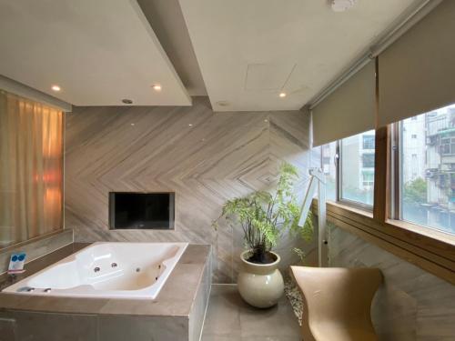 a large bathroom with a tub and a tv at Tango Motel in Taipei