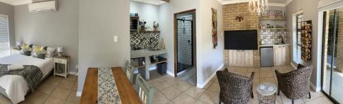 a living room with a bed and a tv in a room at UpperRoom Ceres -Indoor Braai in Ceres