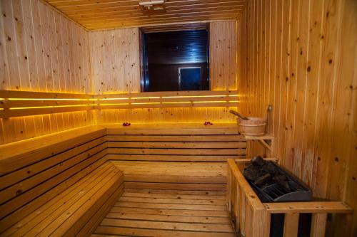 a wooden sauna with a tub and a window at Queen Ann Nha Trang Hotel in Nha Trang