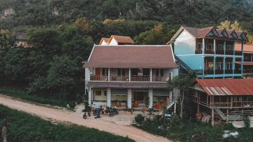a large house with motorcycles parked in front of it at Arthith Guesthouse in Nongkhiaw