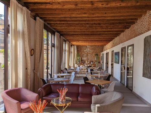 a restaurant with leather couches and tables and windows at Dependance del Brenta in Fiesso dʼArtico
