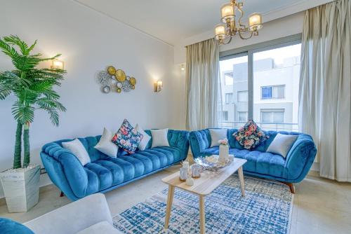 a living room with blue couches and a table at Residential Suites near AUC by ELEGANT in Cairo