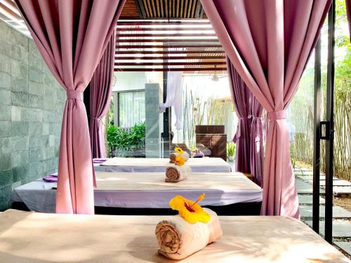 two beds in a room with pink curtains at SENVILA Boutique Resort & Spa in Hoi An