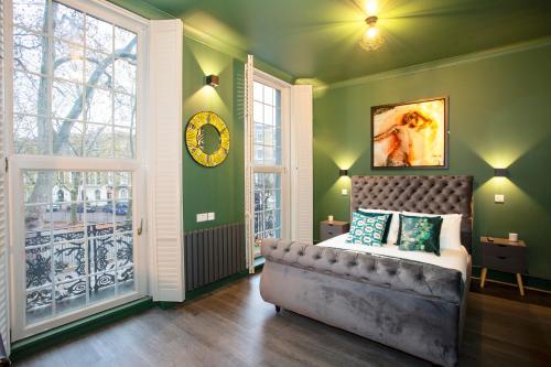 a bedroom with a bed and a clock on the wall at The Rokxy Townhouse & Residences - Kings Cross in London