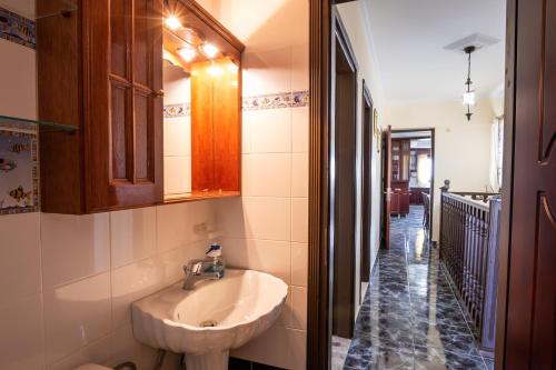 a bathroom with a sink and a mirror and a hallway at Oceanviewvilla in Karpathos