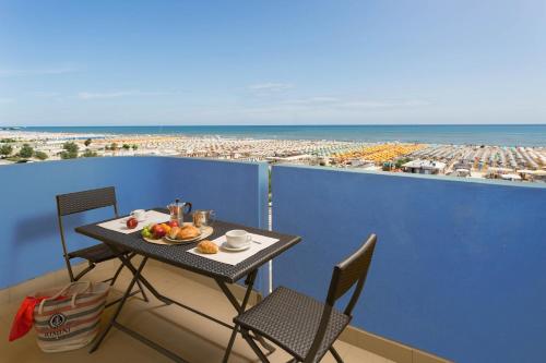 a table with a plate of fruit on top of a balcony at Residence Hotel Piccadilly in Rimini