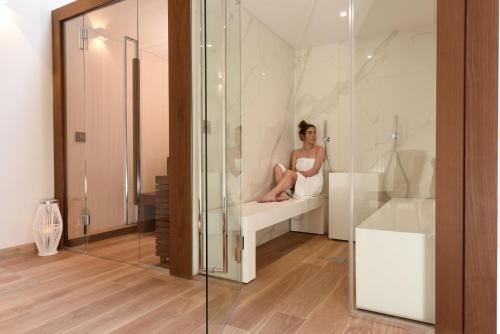a woman sitting on a shelf in a glass room at Dependance del Brenta in Fiesso dʼArtico
