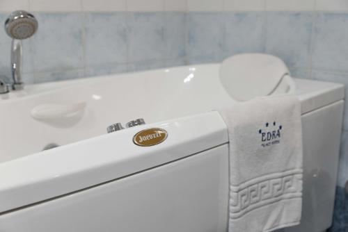 a white bathroom with a sink and a towel on a toilet at Edra Palace Hotel & Ristorante in Cassino