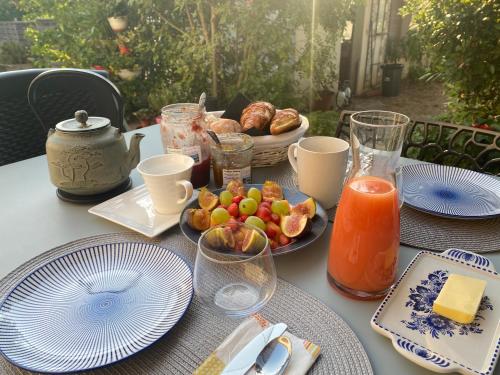 une table avec une assiette de fruits et de jus dessus dans l'établissement Mas des Tournevents, à Lézignan-Corbières