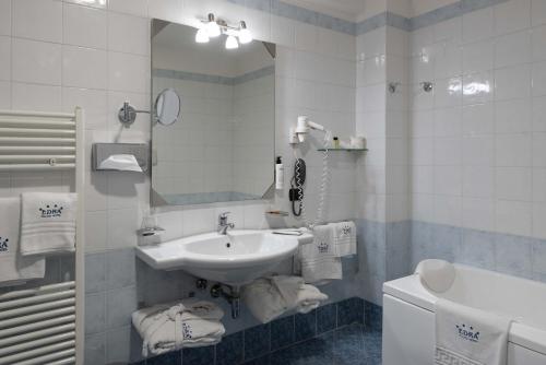 a bathroom with a sink and a mirror and a tub at Edra Palace Hotel & Ristorante in Cassino