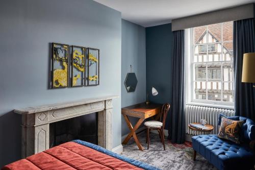a bedroom with a fireplace and a bed and a desk at Hotel Indigo - Stratford Upon Avon by IHG in Stratford-upon-Avon