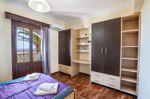 1 dormitorio con cama, estanterías y ventana en Oceanviewvilla, en Karpathos