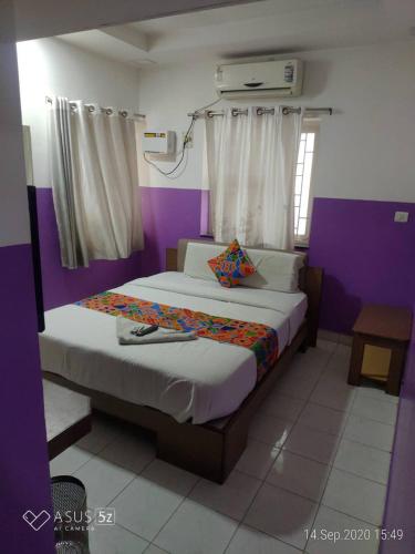 a bedroom with a large bed with purple walls at GT Service apartments in Chennai