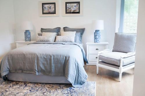 ein Schlafzimmer mit einem Bett und einem Stuhl in der Unterkunft Leura Maples 1BR Cosy Cottage Minutes to village in Leura