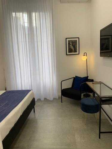 een slaapkamer met een bed, een bureau en een stoel bij Sellaria4 Guest House in Napels