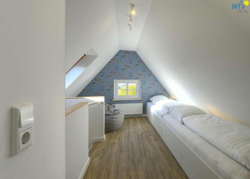 une chambre mansardée avec un canapé et une fenêtre dans l'établissement Haus am Dorfbrunnen Ferienwohnung Meer, à Wangerooge