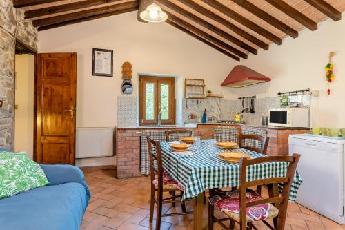 a kitchen and dining room with a table and chairs at Il Colletto Romantic Stonehouse in Pescia